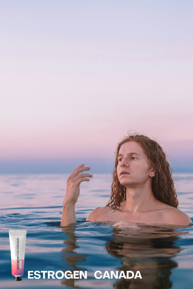 A woman floats in the ocean, reaching out with her hand, surrounded by tranquil blue waters.