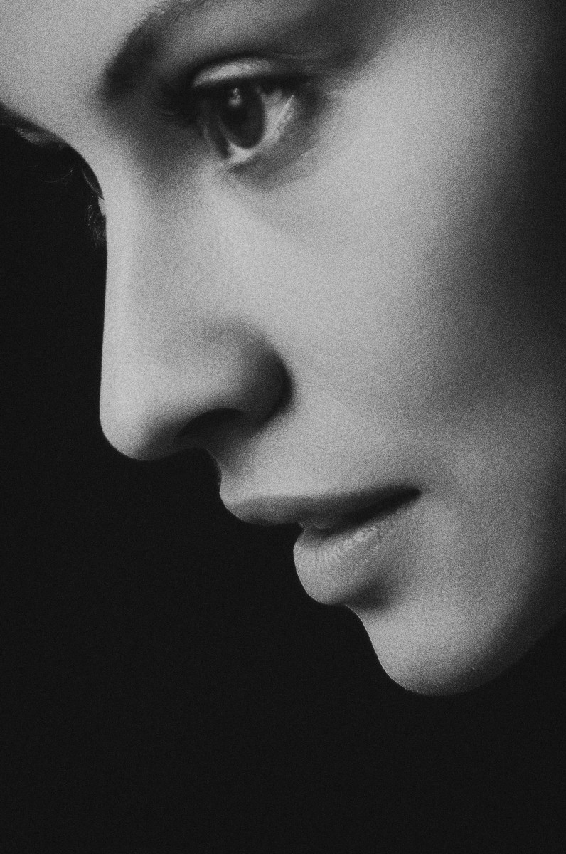 Close-up black and white image of a person's face in profile, highlighting the eyes, nose, and lips.